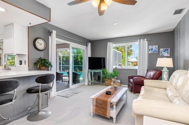 living room featuring light colored carpet and ceiling fan