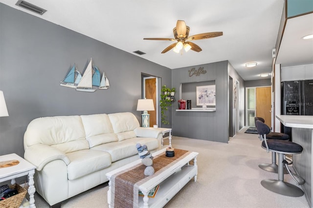 living room featuring ceiling fan and light colored carpet