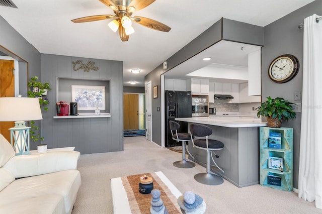 carpeted living room featuring ceiling fan