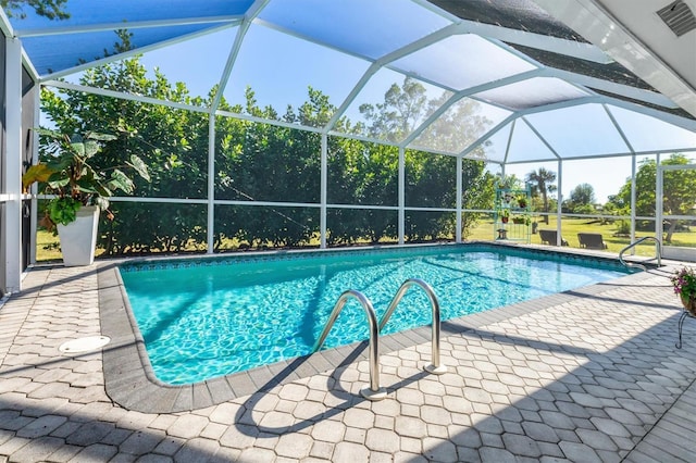 view of pool with glass enclosure and a patio area