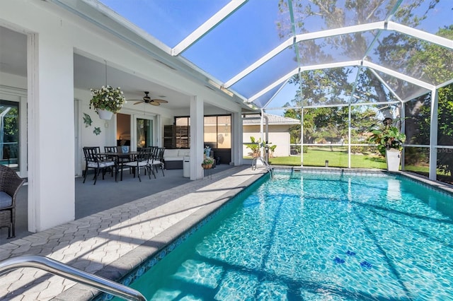 view of swimming pool featuring glass enclosure, ceiling fan, and a patio area