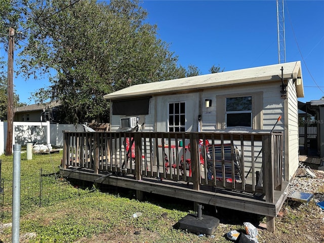 rear view of house featuring a lawn and a deck