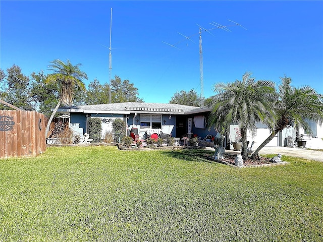 rear view of property featuring a garage and a yard