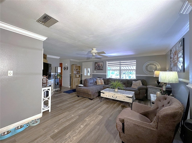 living room with a textured ceiling, ceiling fan, crown molding, and hardwood / wood-style floors