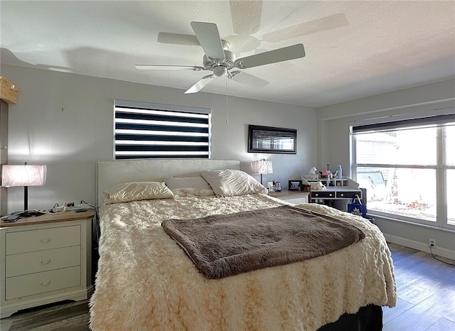 bedroom with ceiling fan, wood-type flooring, and a textured ceiling