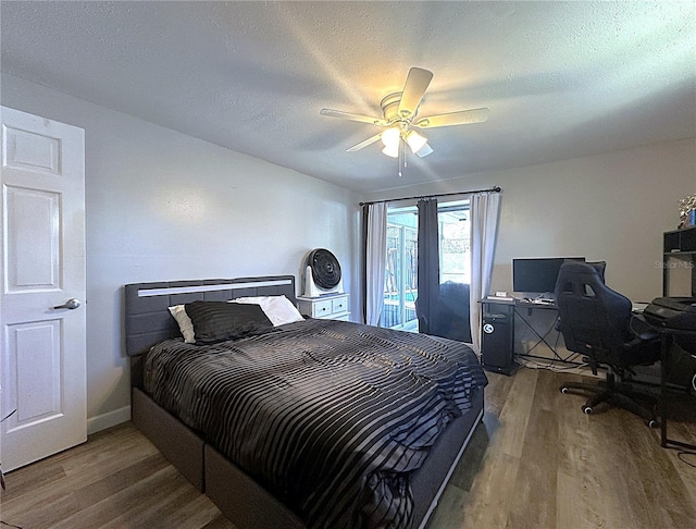 bedroom with access to exterior, ceiling fan, a textured ceiling, and hardwood / wood-style flooring