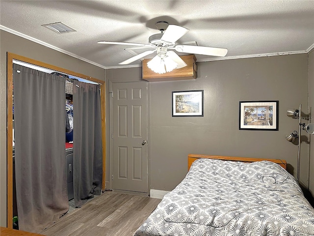 bedroom with a textured ceiling, light hardwood / wood-style floors, ceiling fan, and crown molding