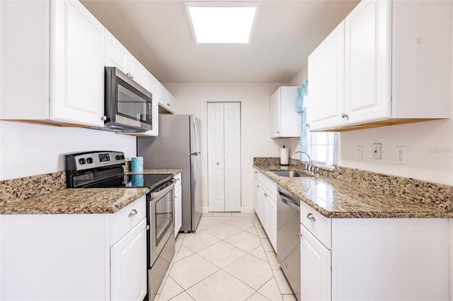 kitchen with white cabinets, sink, light tile patterned flooring, light stone counters, and stainless steel appliances