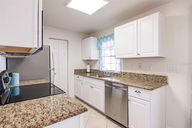 kitchen featuring dishwasher, black range oven, sink, light tile patterned floors, and white cabinetry