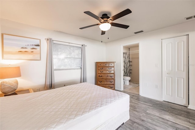 bedroom with wood-type flooring, ensuite bathroom, and ceiling fan