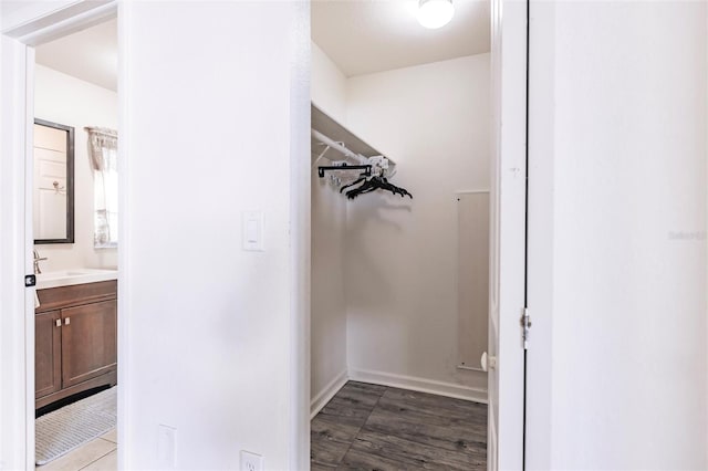 walk in closet with dark hardwood / wood-style floors and sink