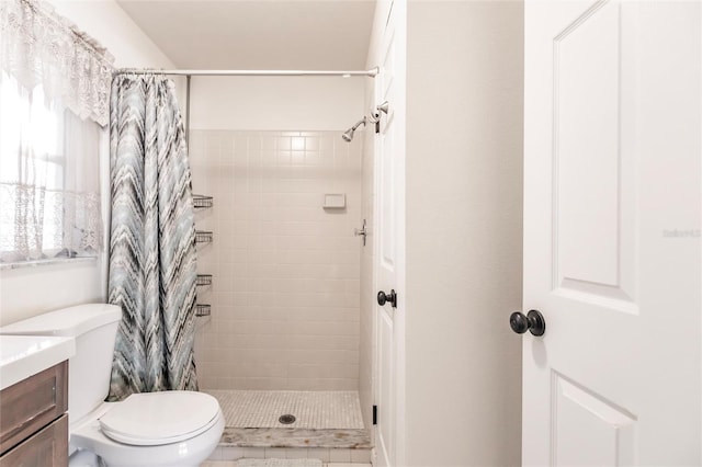 bathroom featuring tile patterned floors, toilet, vanity, and walk in shower