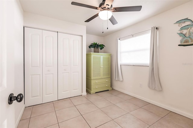 unfurnished bedroom featuring ceiling fan, light tile patterned floors, and a closet