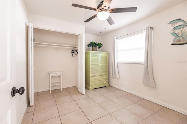 unfurnished bedroom featuring ceiling fan, light tile patterned floors, and a closet