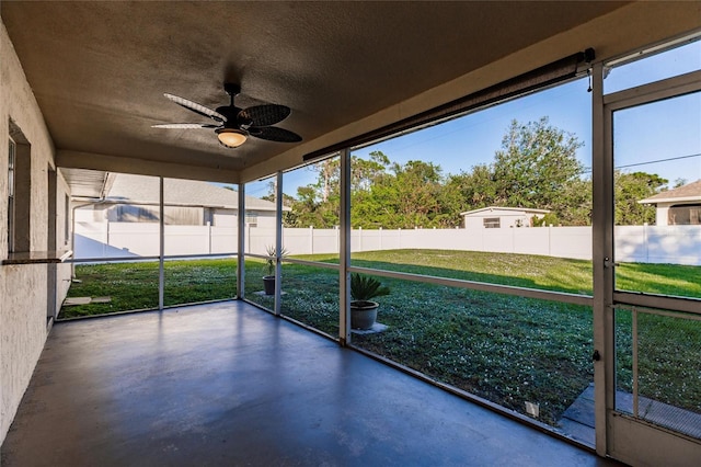 unfurnished sunroom featuring ceiling fan