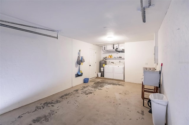 garage featuring washing machine and clothes dryer, electric panel, and electric water heater