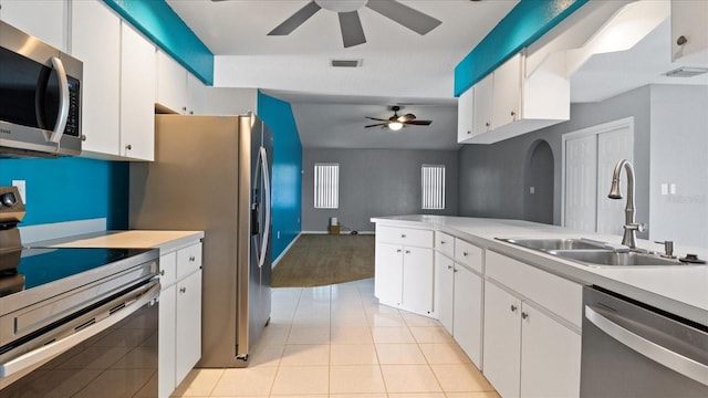 kitchen featuring ceiling fan, white cabinetry, sink, light tile patterned flooring, and appliances with stainless steel finishes