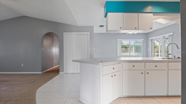 kitchen with white cabinetry, light tile patterned floors, and lofted ceiling