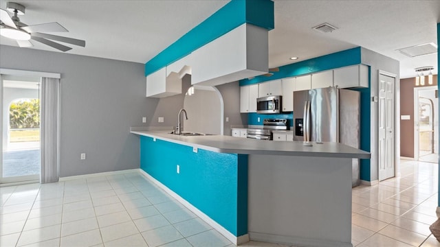 kitchen with kitchen peninsula, white cabinetry, sink, and appliances with stainless steel finishes