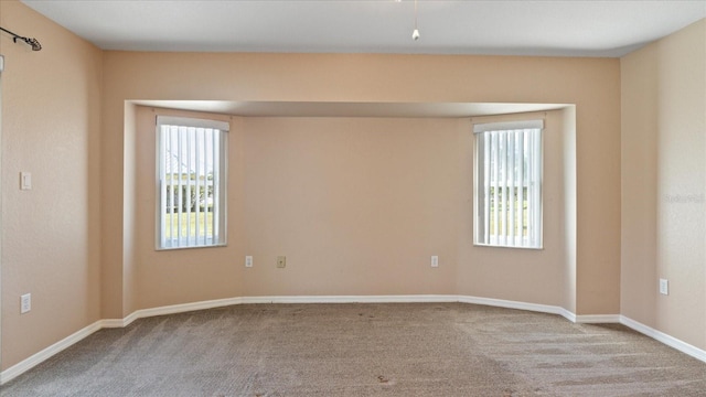 carpeted empty room featuring a wealth of natural light