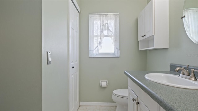 bathroom with tile patterned flooring, vanity, and toilet