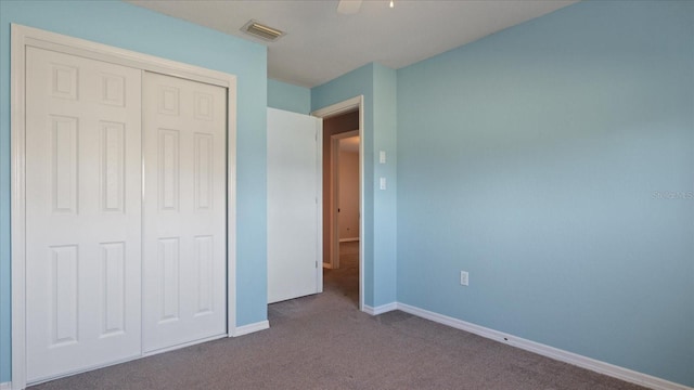 unfurnished bedroom with ceiling fan, carpet floors, and a closet