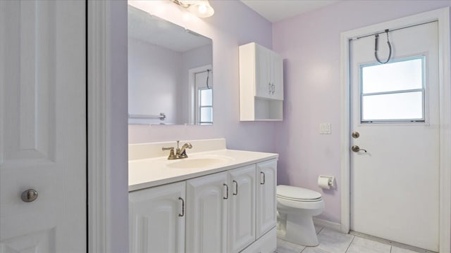 bathroom featuring tile patterned flooring, vanity, toilet, and plenty of natural light