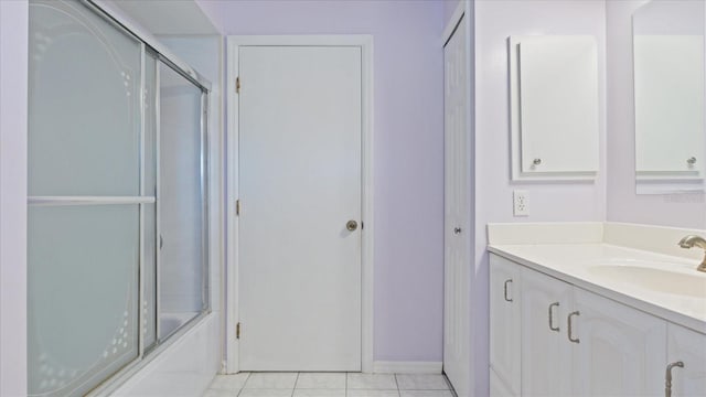 bathroom featuring tile patterned flooring, vanity, and enclosed tub / shower combo