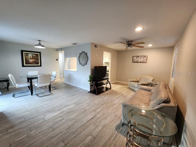 living room featuring ceiling fan and light wood-type flooring