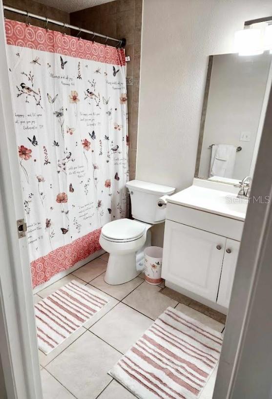 bathroom with tile patterned flooring, vanity, and toilet