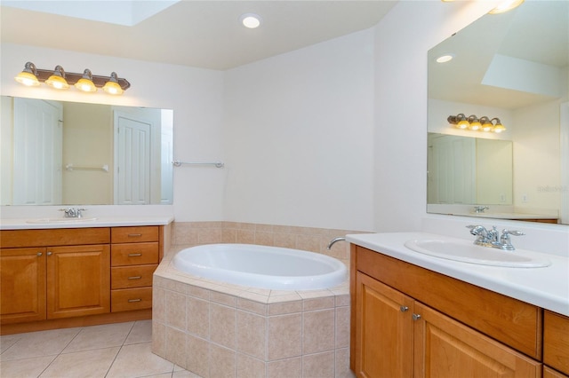 bathroom featuring tile patterned flooring, vanity, and tiled bath