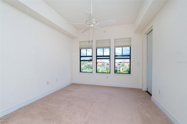 spare room with ceiling fan and light carpet