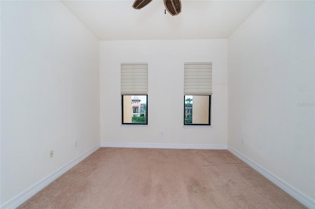 carpeted spare room featuring ceiling fan