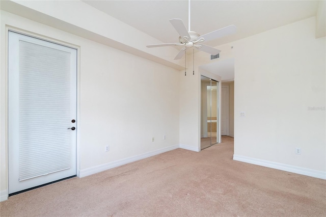 empty room featuring ceiling fan and light colored carpet