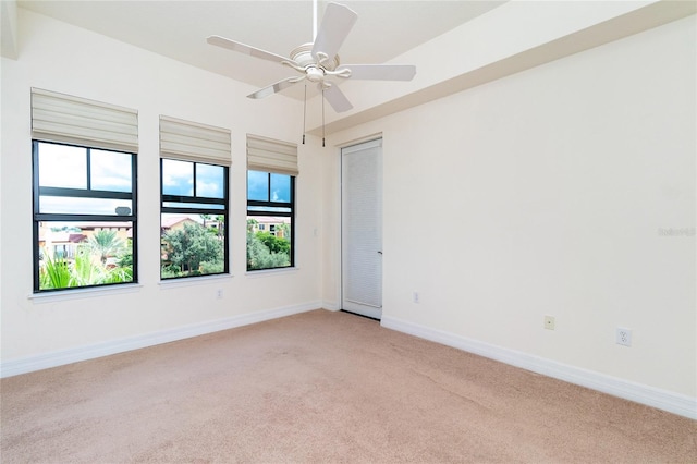 carpeted spare room with ceiling fan