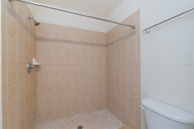 bathroom with tiled shower and toilet