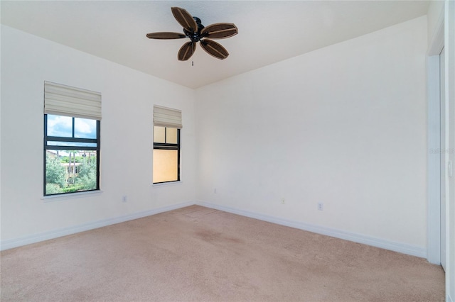 spare room with ceiling fan and light colored carpet