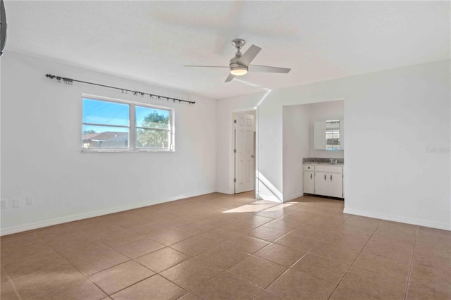 tiled spare room featuring ceiling fan