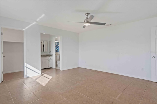 tiled spare room with ceiling fan