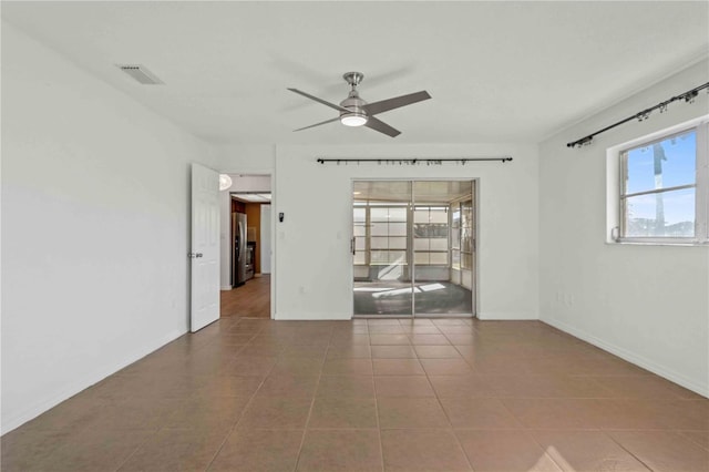 tiled spare room with ceiling fan