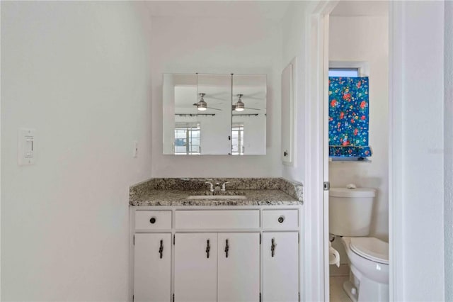 bathroom featuring vanity, toilet, and ceiling fan