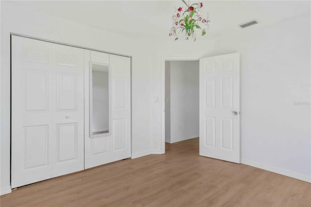 unfurnished bedroom featuring a closet and light hardwood / wood-style floors