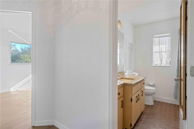 bathroom with hardwood / wood-style floors, vanity, and toilet