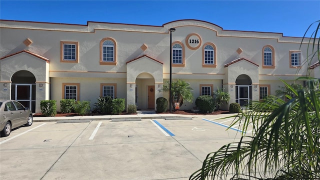 mediterranean / spanish-style home with uncovered parking and stucco siding