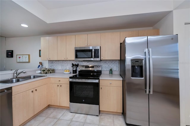 kitchen with light brown cabinets, stainless steel appliances, tasteful backsplash, and sink