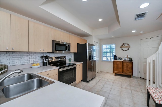 kitchen featuring a sink, visible vents, light countertops, appliances with stainless steel finishes, and a tray ceiling