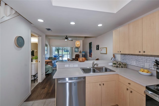 kitchen with a sink, open floor plan, light countertops, dishwasher, and light brown cabinetry