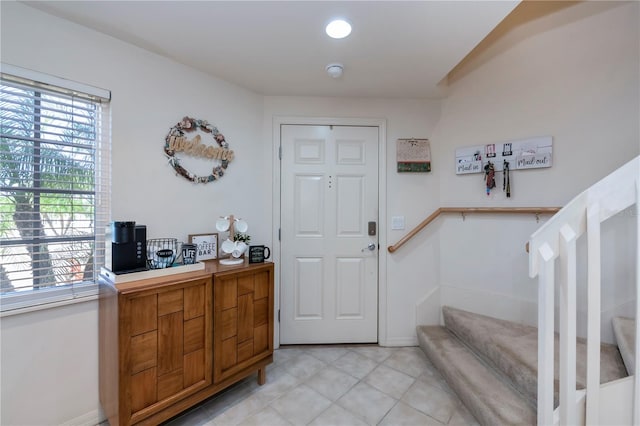 entrance foyer with stairway and light tile patterned flooring