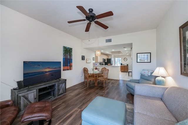 living room featuring ceiling fan and dark wood-type flooring