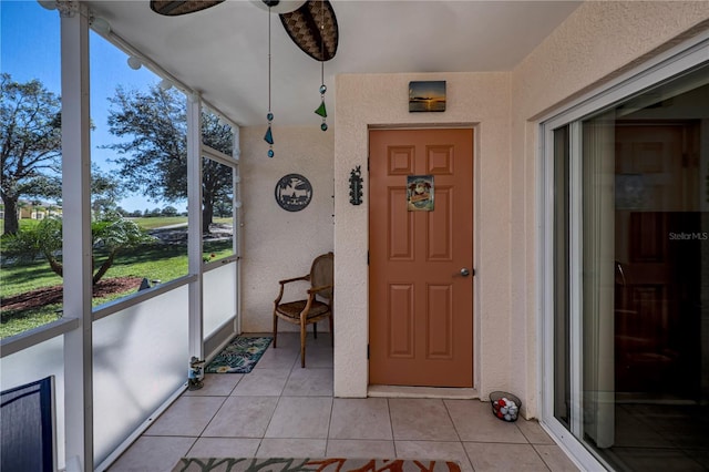 unfurnished sunroom featuring ceiling fan